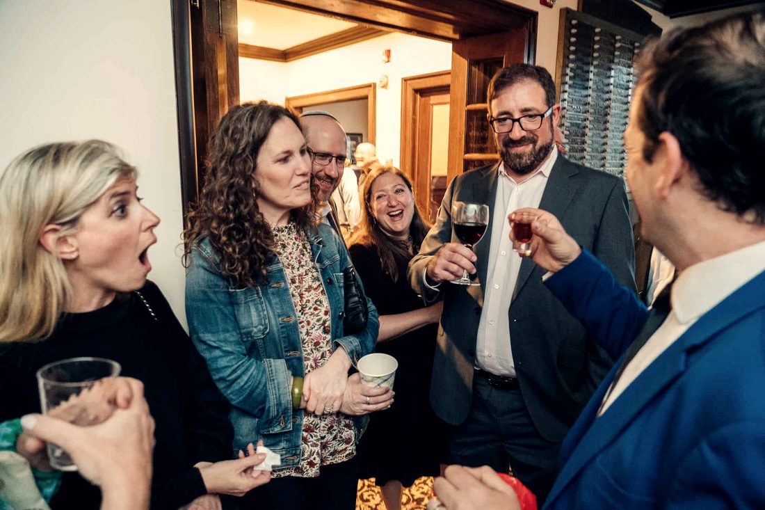 Guests reacting in disbelief during close-up magic at a corporate reception