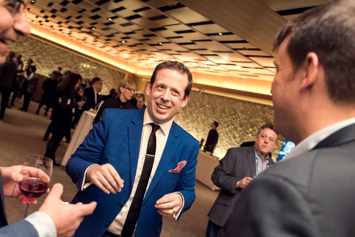 Eric Lerner laughing with guests at a corporate reception
