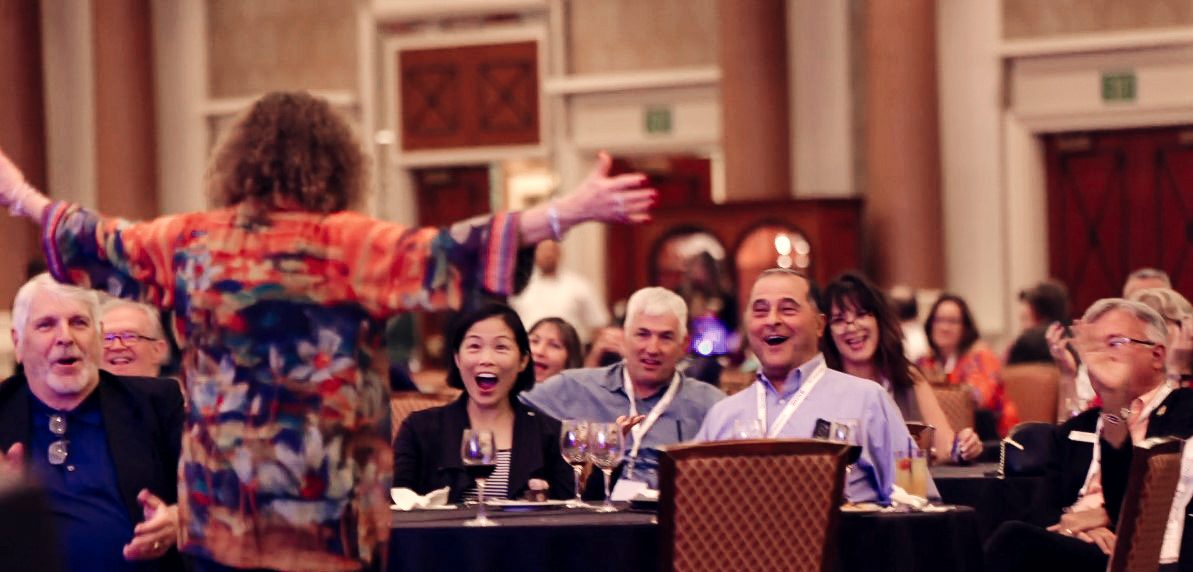 A corporate audience laughing and reacting during Eric Lerner's stage show