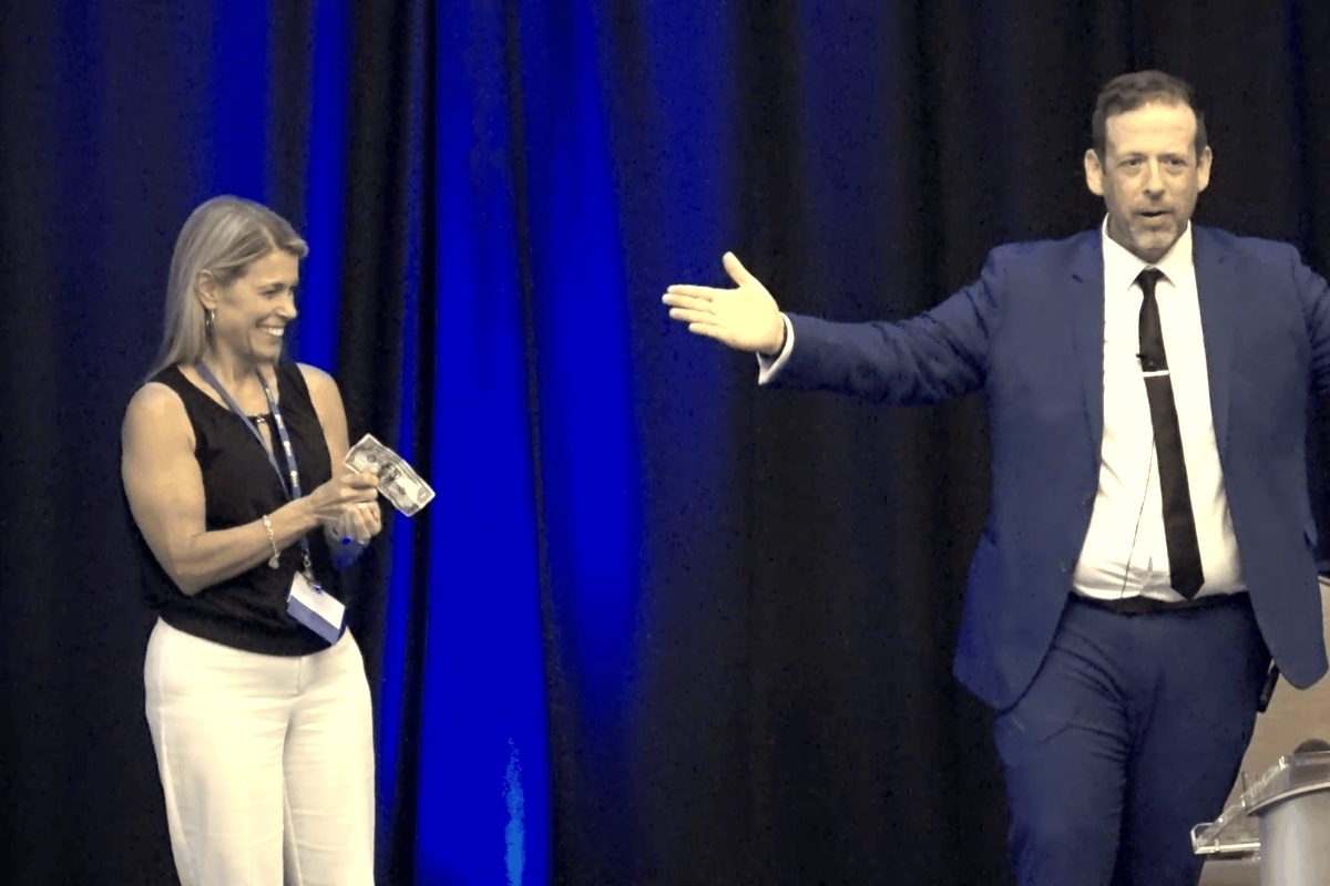 Eric Lerner presenting to a volunteer on stage during a corporate awards evening