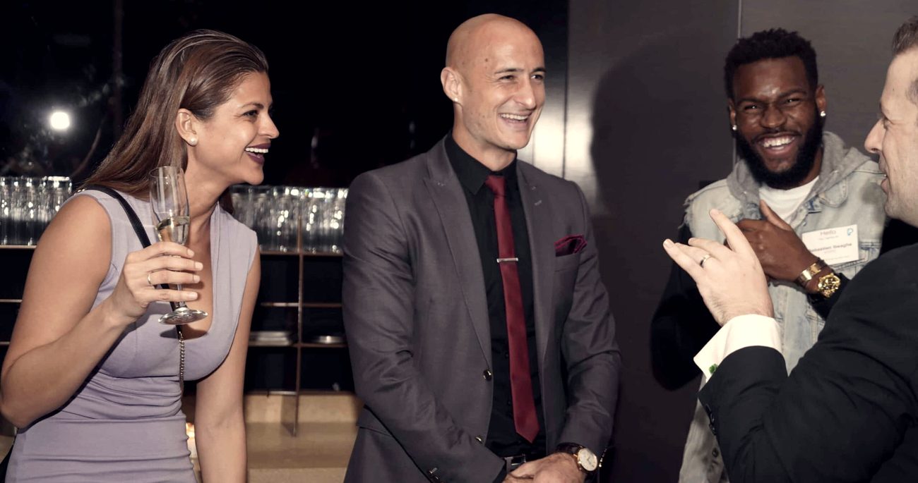 Guests laughing together during a drinks reception