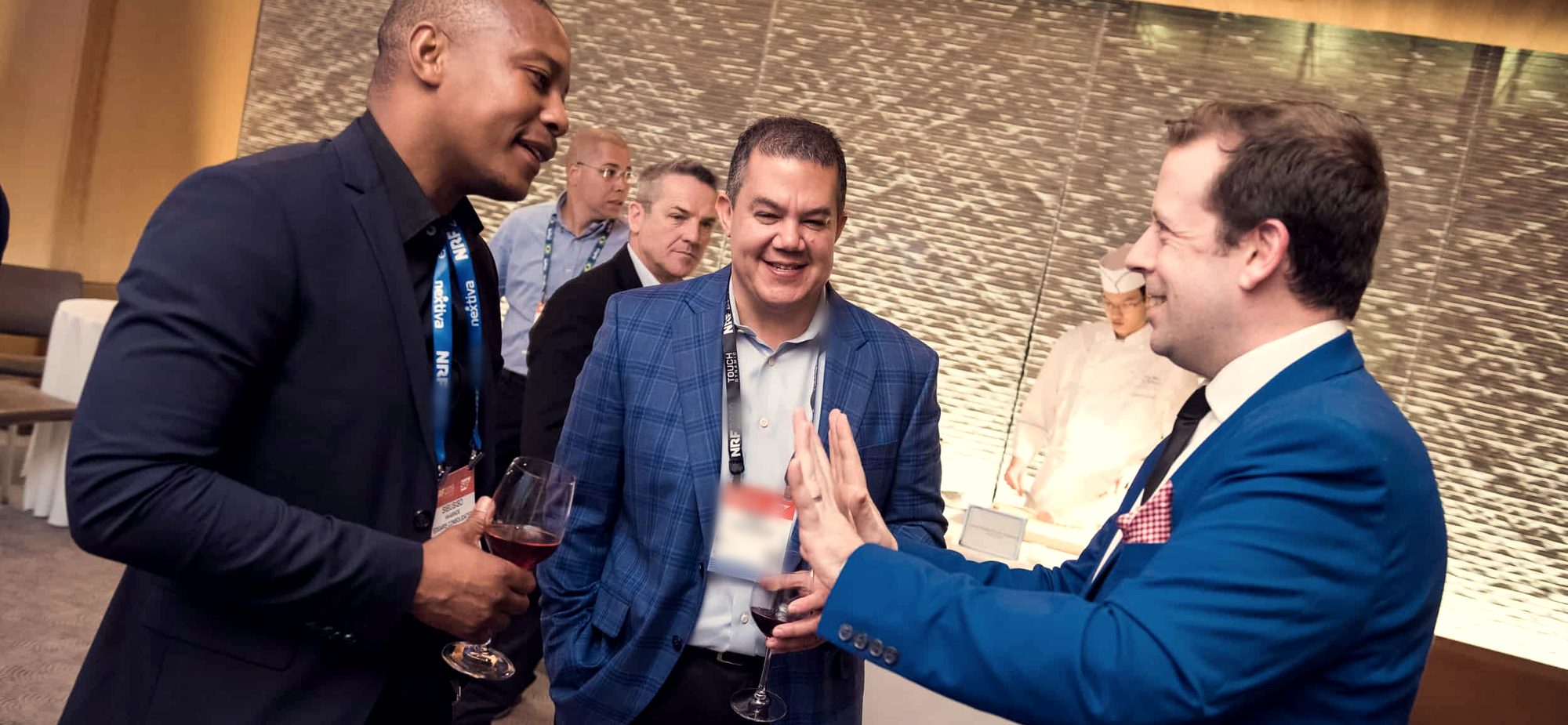 Guests laughing as Eric Lerner performs close-up magic at a cocktail reception