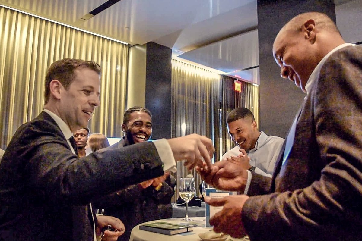 Eric Lerner performing close-up magic for a small group of guests at a corporate reception