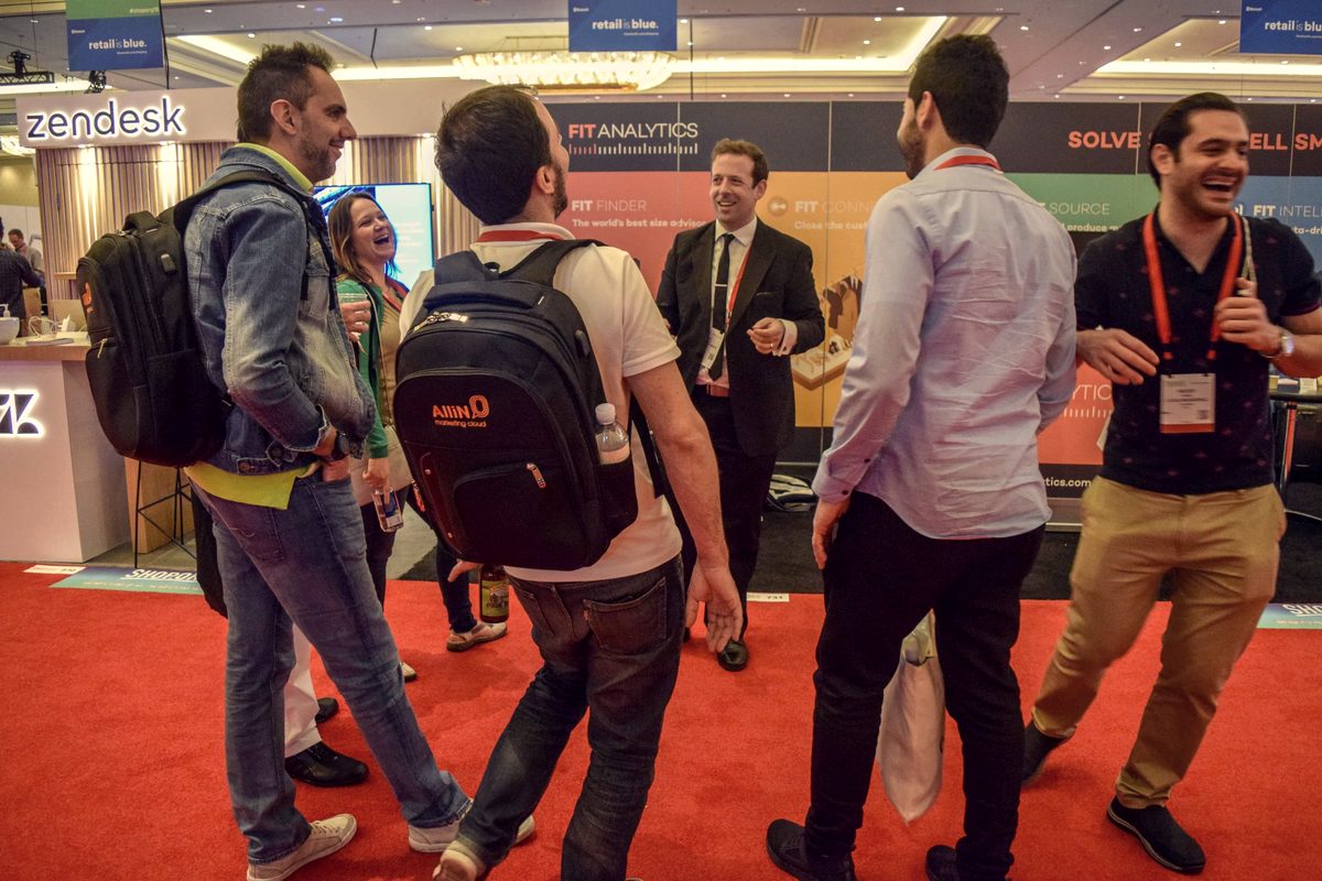 Eric Lerner drawing a crowd at a company booth on a trade show floor