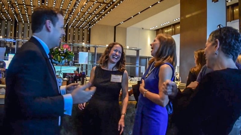 Guests gathered around Eric Lerner during close-up magic at a cocktail hour