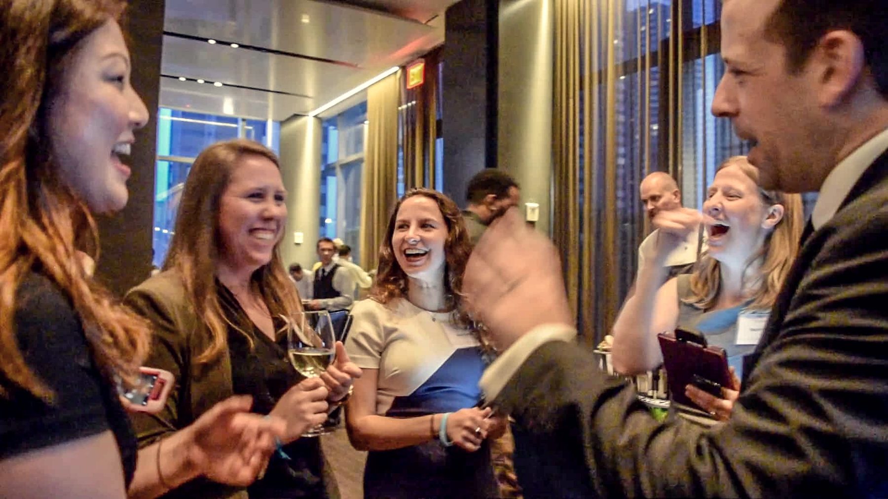 Guests laughing together as Eric Lerner performs at a corporate reception