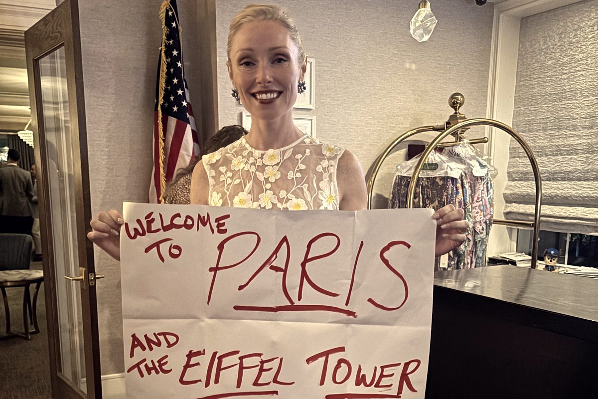 A bride laughing as she holds up Eric Lerner's written prediction of her honeymoon destination