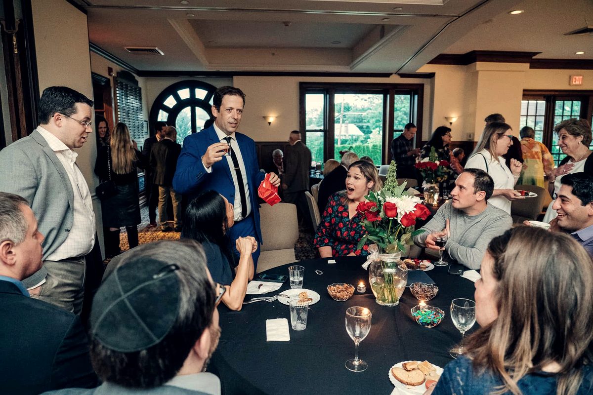 Eric Lerner performing close-up magic at a reception table during dinner
